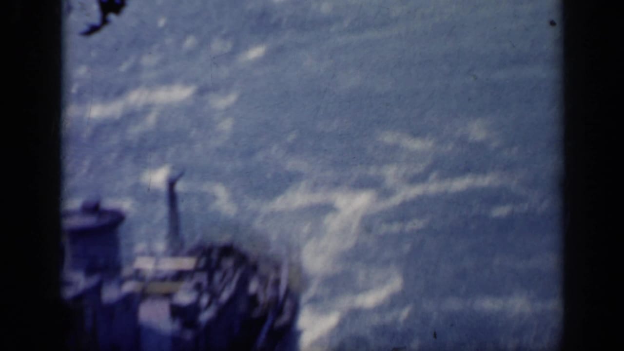 Blurred deck or vessel edge beside foaming blue water.