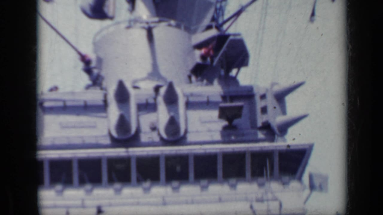 Close 8mm view of shipboard radar and antenna hardware above the bridge, consistent with the 1962 Italy metadata.