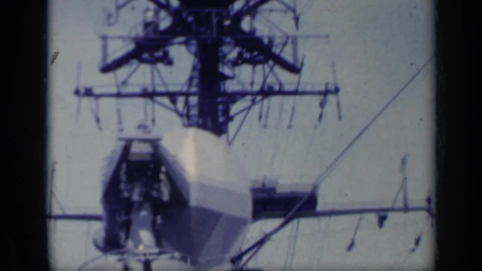 1962 Italy home-movie frame showing radar mast hardware, antennas, and part of a white ship bridge.