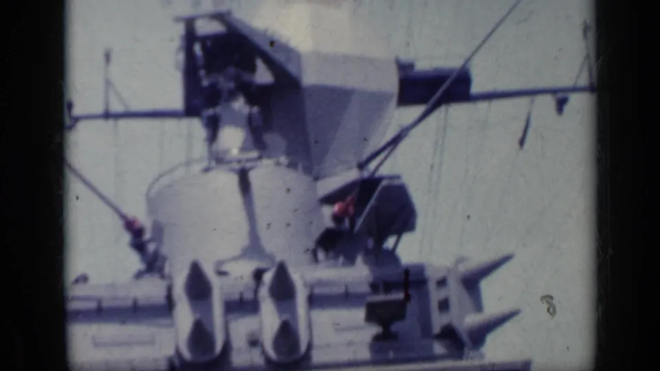 Final 8mm frame of the white ship bridge and radar equipment, with antennas crossing a bright sky.