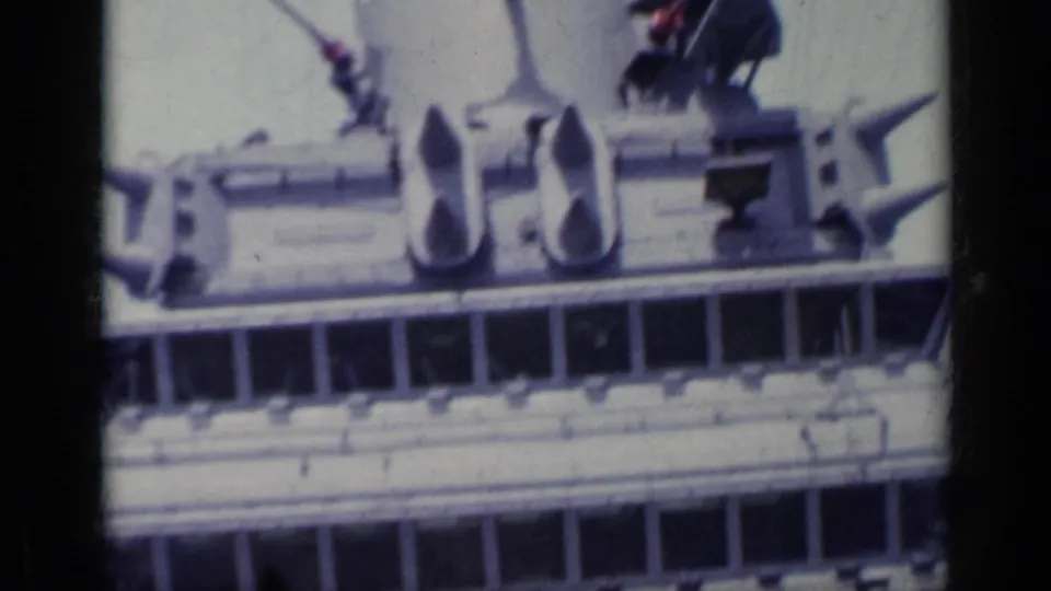1962 Italy 8mm frame showing a close, soft-focus view of cruise ship superstructure, railings and deck equipment.