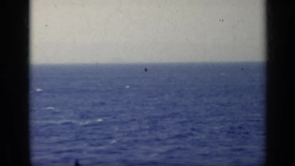 1962 Italy 8mm frame showing a wide open sea, pale sky, hazy horizon, and visible film-frame edge.