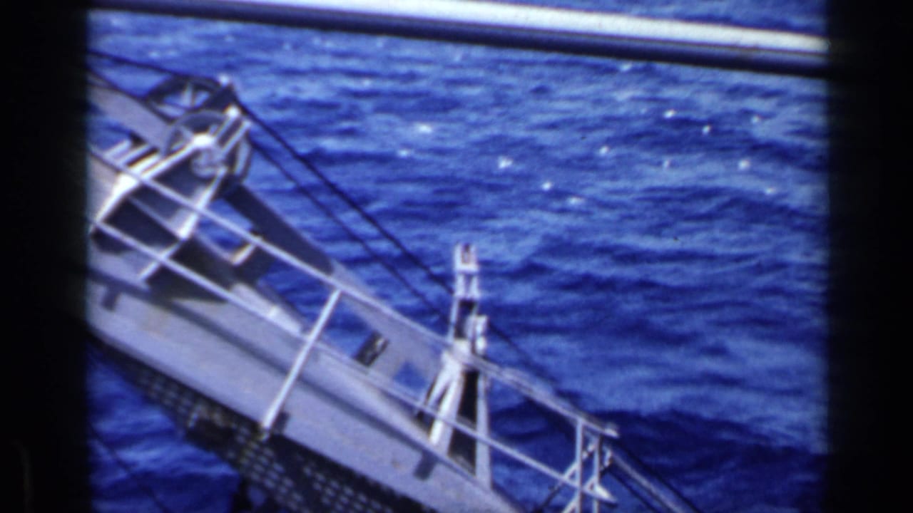Metal gangway or railing structure angles over deep blue water.