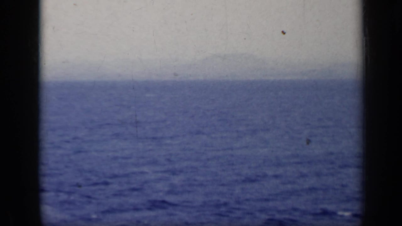 Blue lake water with a hazy distant shoreline and dark vertical frame edges.