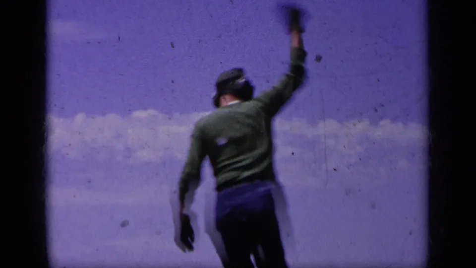 The final frame shows a Navy deck crewman in green signaling during carrier activity, with cloudy sky and 8mm wear visible.
