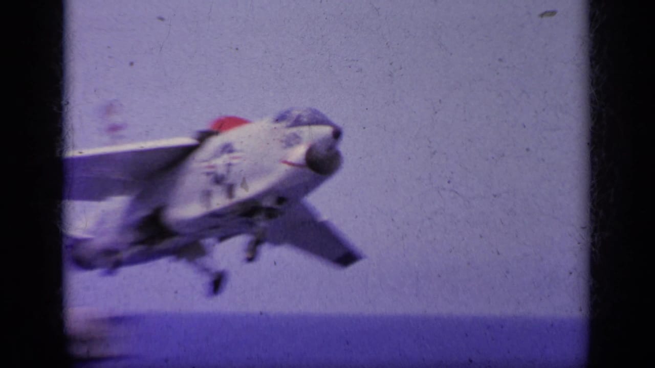Jet aircraft lifting from an aircraft carrier deck over the sea.
