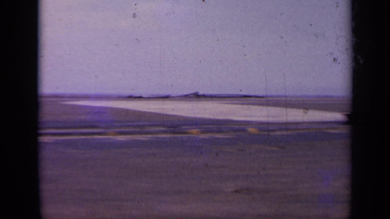 Empty stretch of carrier deck with a pale horizon and purple-shifted film color.