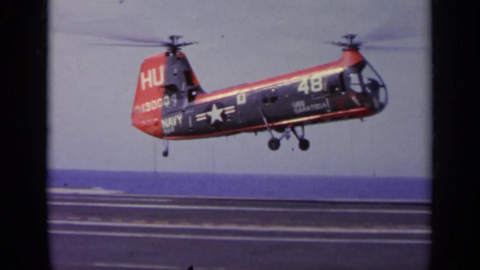 1963 Greece footage showing a U.S. Navy aircraft marked 48 descending over an aircraft carrier deck with the sea horizon behind it.