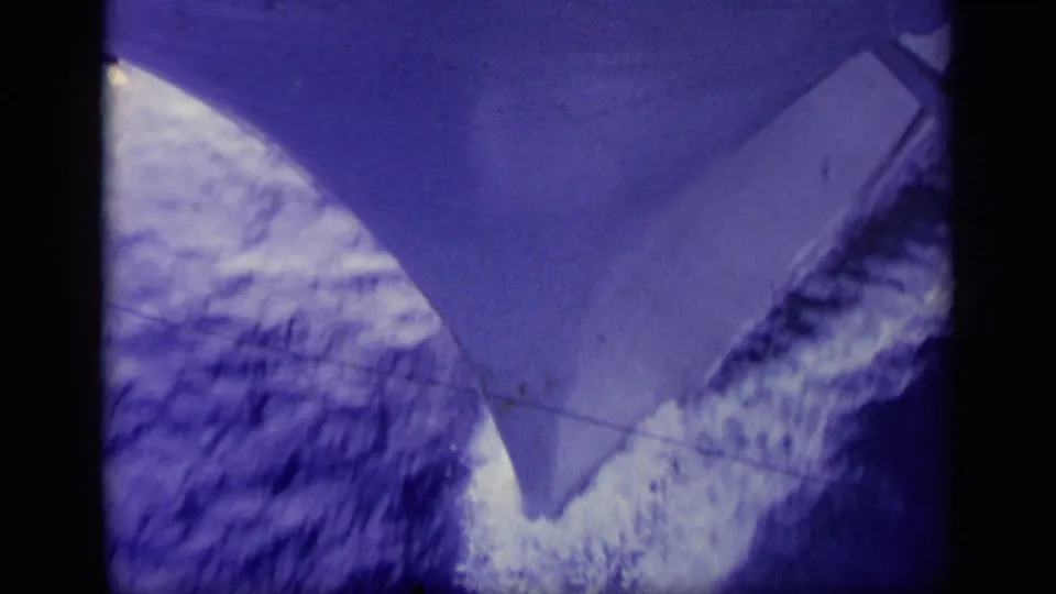 1963 Greece 8mm frame showing a pointed gray bow above deep blue sea and a bright white wake.