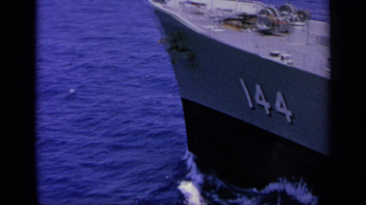 Bow of a ship marked 144 moving through blue water.
