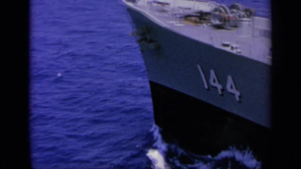 Close view of a gray ship bow with hull number 144 cutting through deep blue water in 1963 Greece-labeled footage.