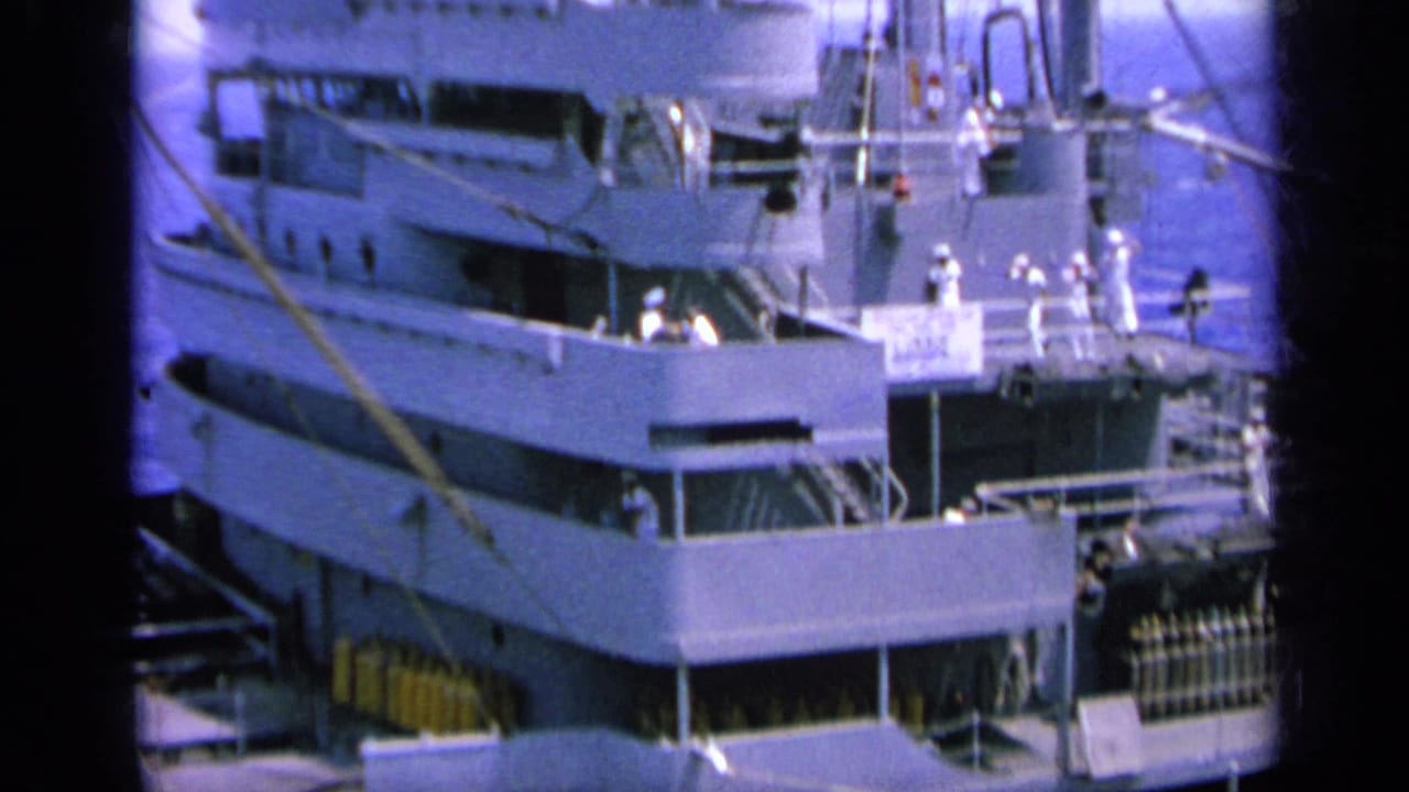 1963 Greece 8mm frame showing a naval ship at port with crew in white uniforms standing along the deck levels.