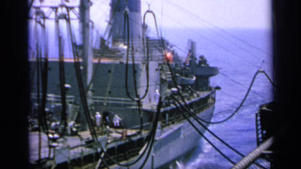 1963 Greece 8mm frame of a large ship's aft area with crew, superstructure, cables and open water beyond.