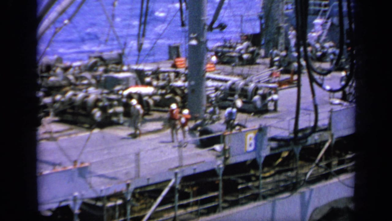 1963 Greece 8mm frame showing a ship deck with rigging, railings, deck equipment, and people visible against blue water.