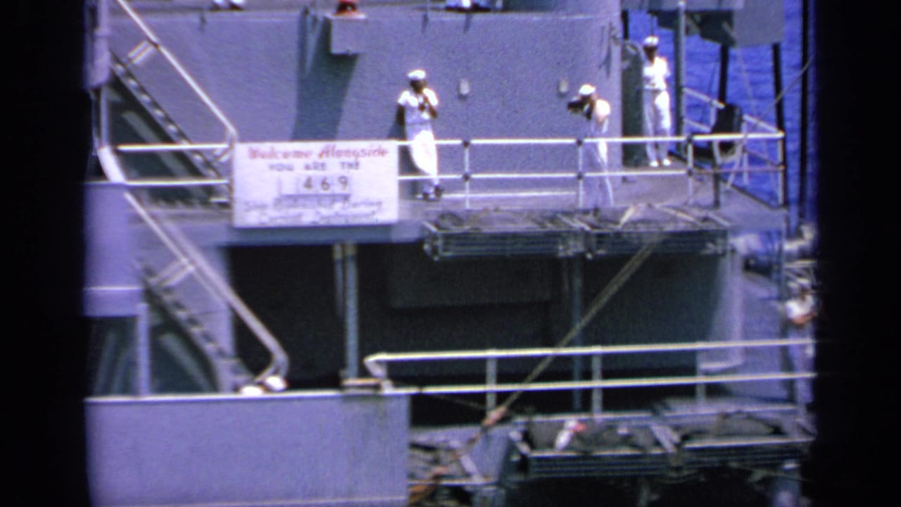 1963 Greece 8mm frame showing uniformed people on a ship platform near railings and a Welcome Aboard sign marked with the number 469.