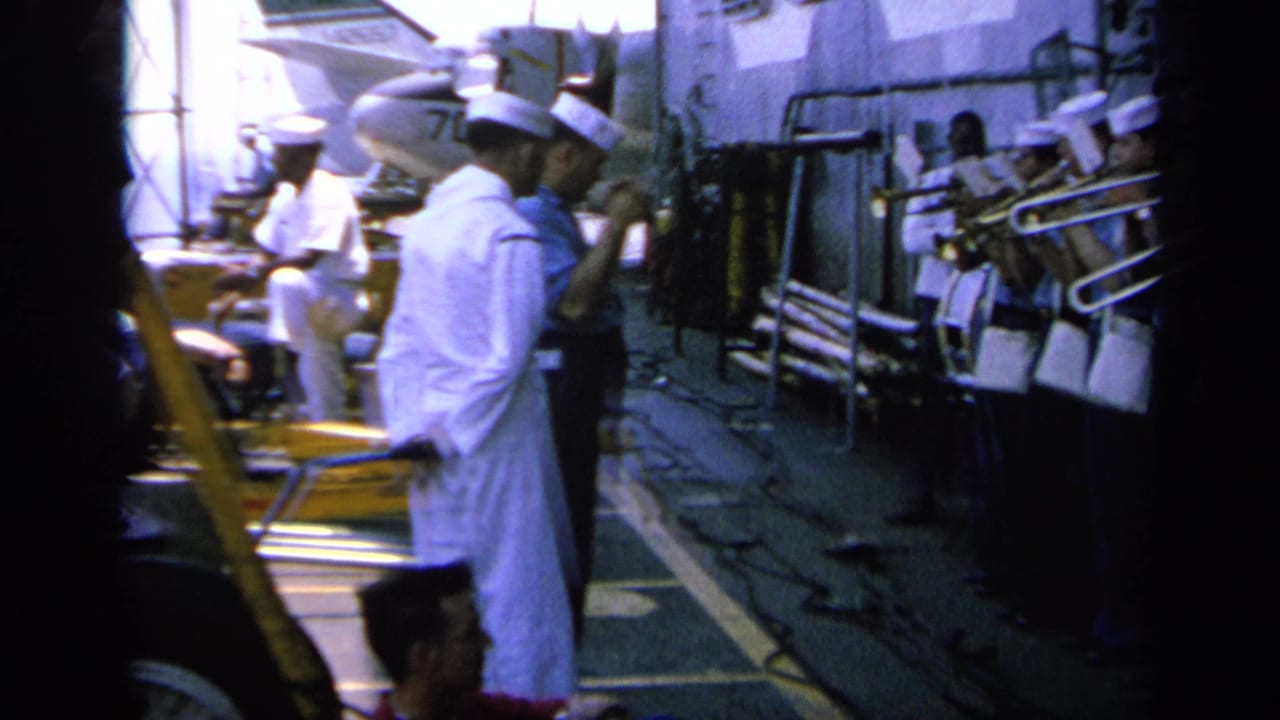 Sailors in white caps gather with brass instruments on a ship deck.