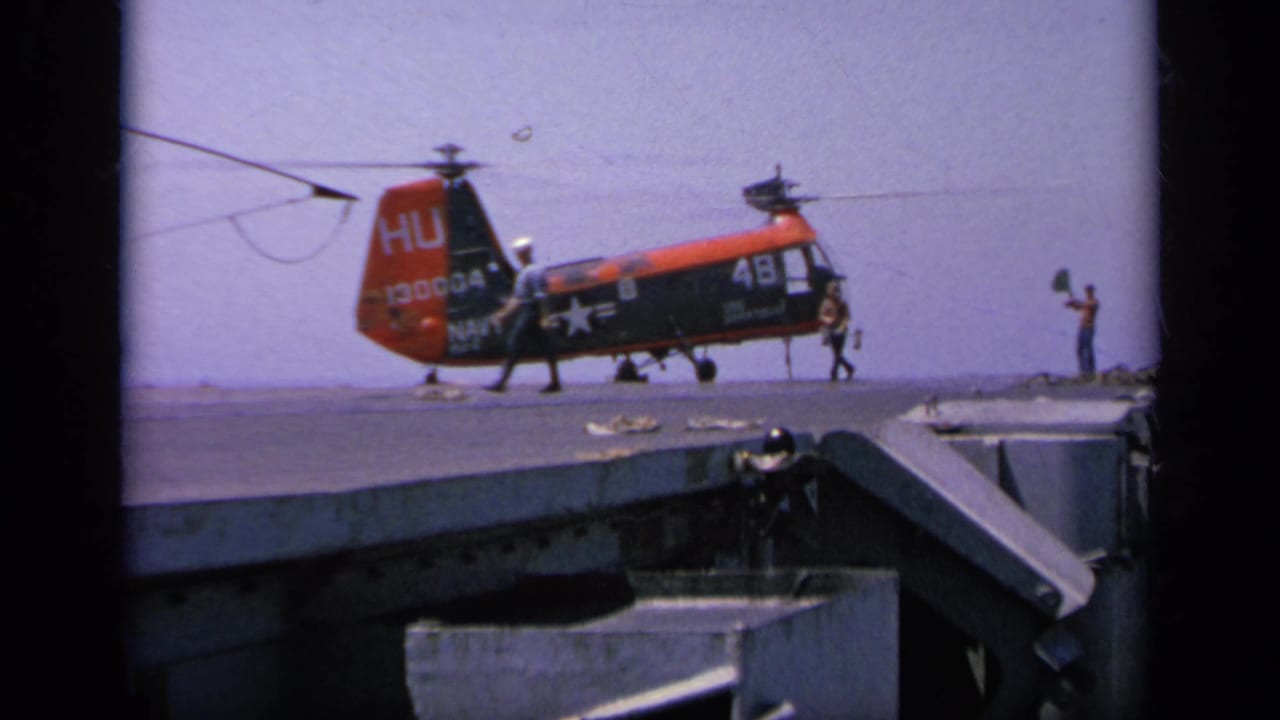 1963 Greece 8mm frame showing the Navy helicopter settled low on the ship deck as crew members move around the aircraft.