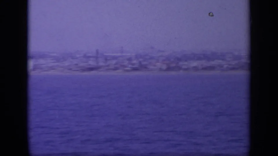 Greek coastal skyline seen from across the water in a soft, blue-purple 8mm frame from 1963.