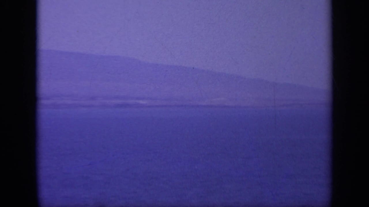1963 Greece 8mm frame showing hazy open water and a faint distant landmass under a purple color cast.