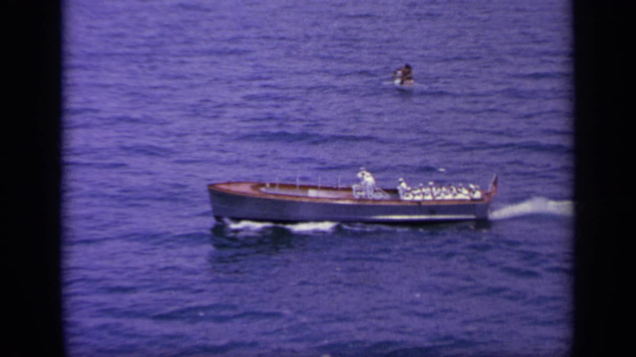 1963 Greece 8mm frame showing a small naval boat with uniformed personnel crossing deep blue water.