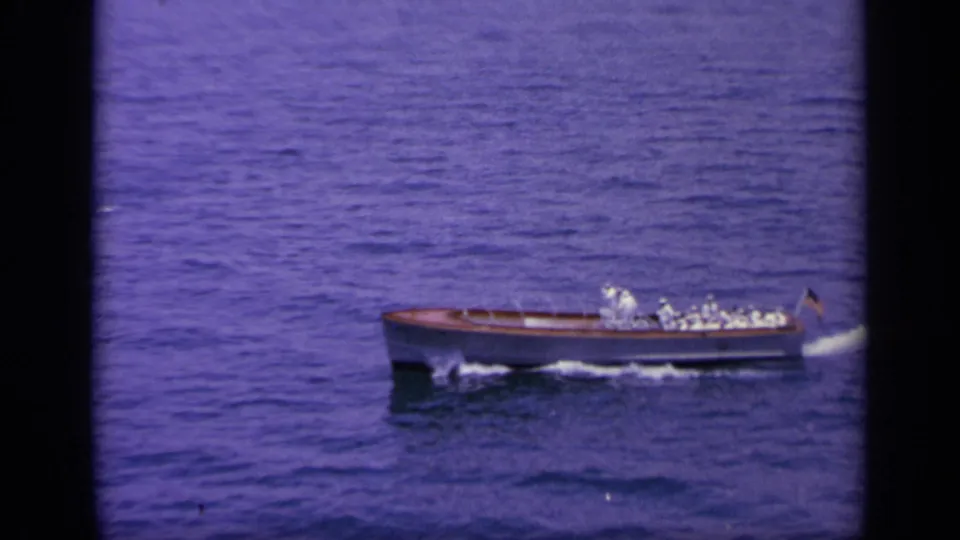 Small naval craft in 1963 Greece footage travels across open water, carrying uniformed figures and leaving a white wake.