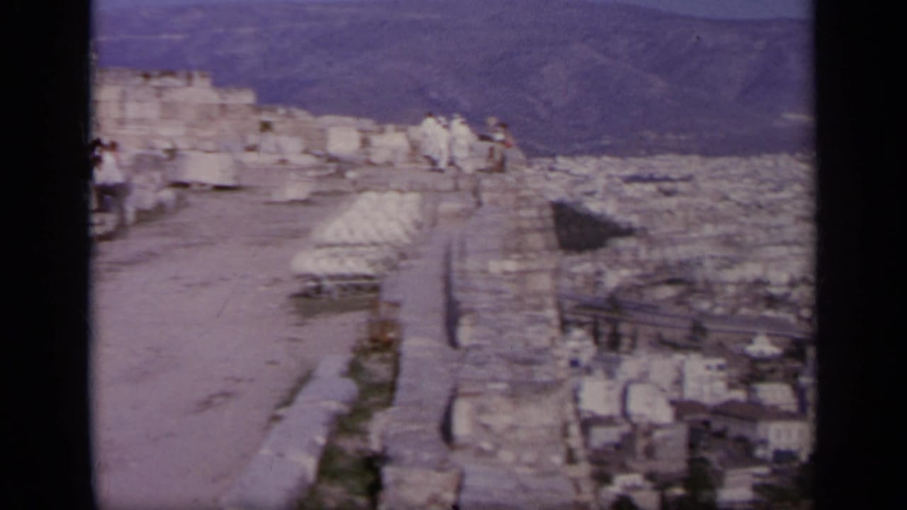 A wider 1963 travel view looks across the Acropolis ruins toward the city of Athens and hills beyond.