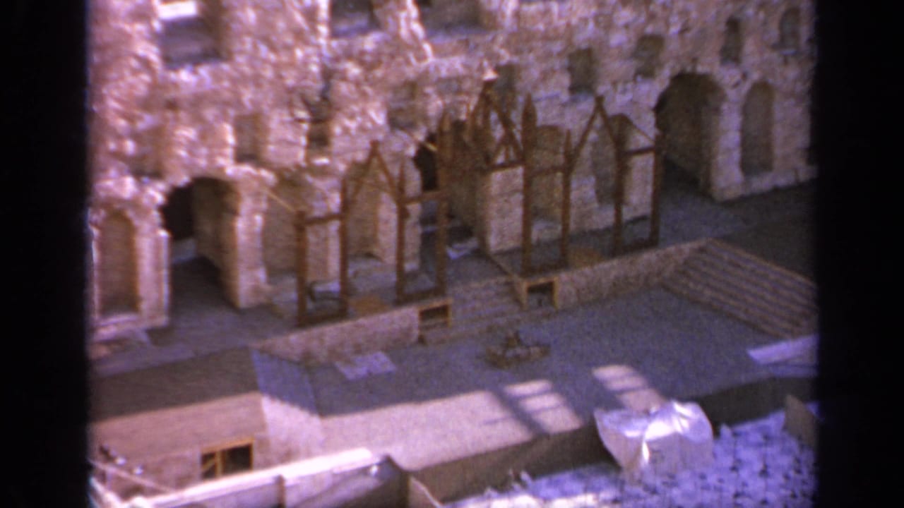 Ancient stone wall with arches, timber supports, and shadowed openings.