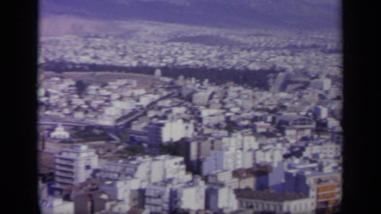 The final 1963 Greece frame shows a broad city panorama from above, with compact buildings stretching toward hazy hills.