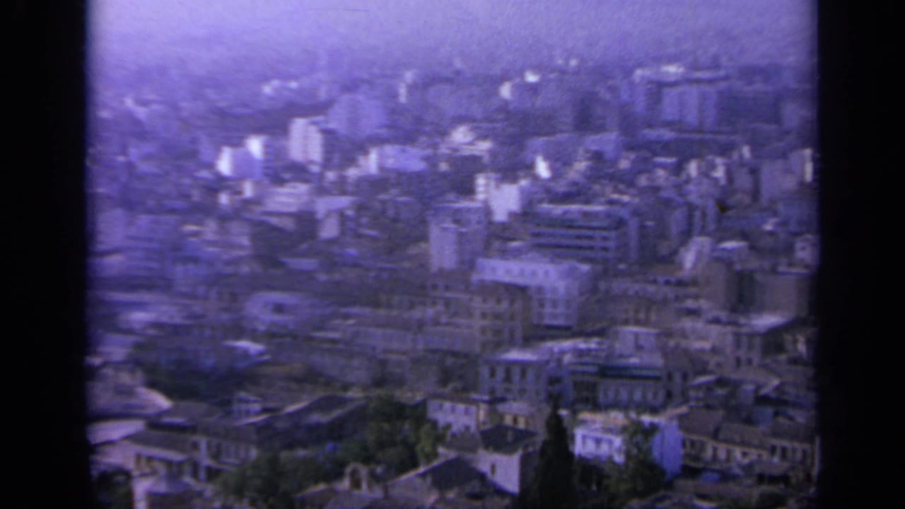Urban skyline with apartment blocks, lower buildings, and haze.