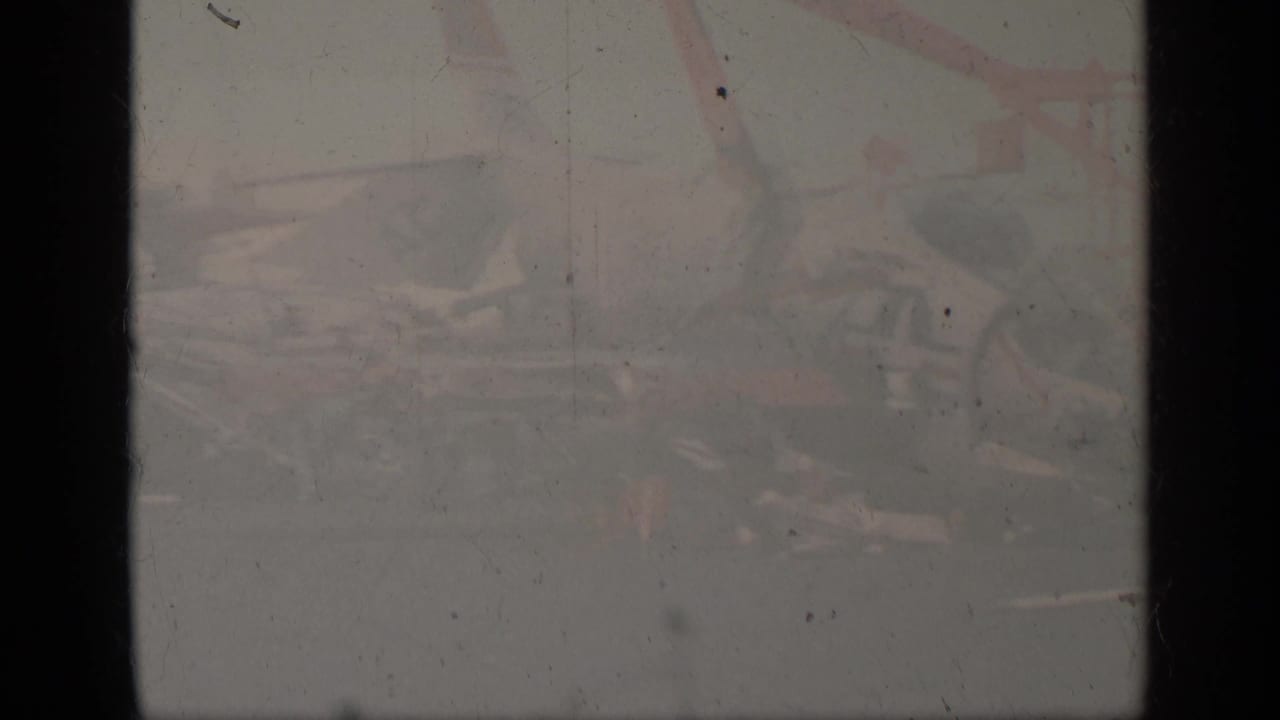 Heavily faded 1963 Greece 8mm frame with a barely visible aircraft scene obscured by exposure, dust, and vertical film borders.