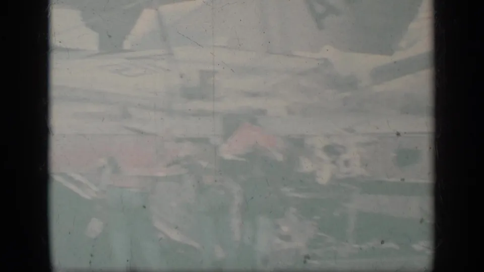 Faded 1963 Greece 8mm frame showing U.S. Navy aircraft shapes and deck equipment on an aircraft carrier.
