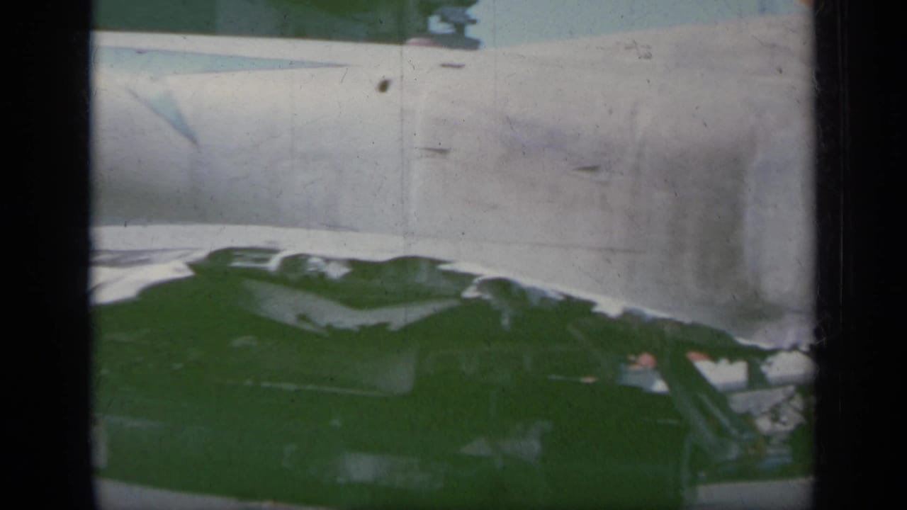 Close view of a burned jet fuselage and damaged wing area on deck.