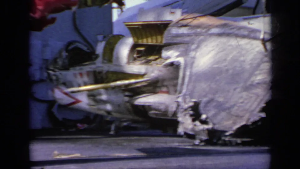 Close 1963 Greece 8mm view of damaged military aircraft wreckage with torn metal and exposed internal structure on deck.