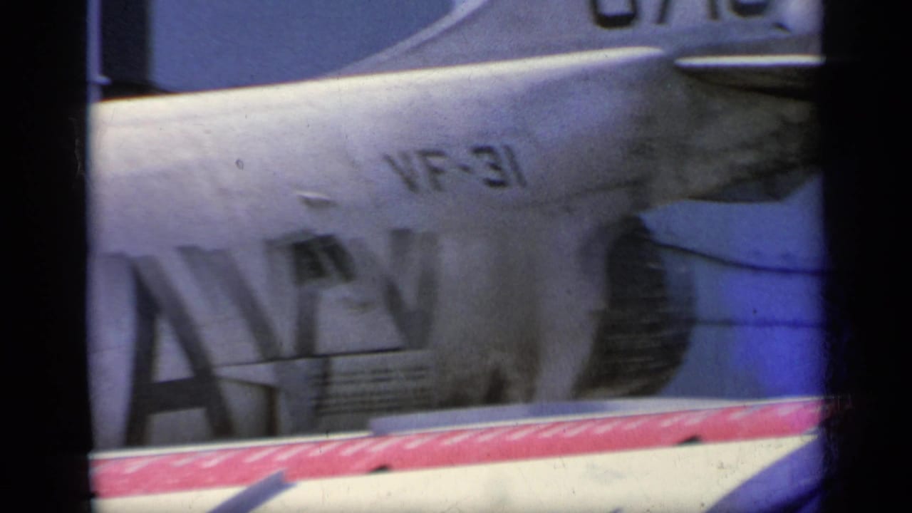 Aircraft fuselage and tail section with partial Navy lettering and VF-31-style marking visible.