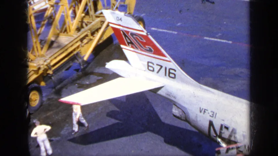 1963 Greece 8mm frame showing an F-104 Starfighter tail marked 6716 beside ground equipment and personnel on the tarmac.