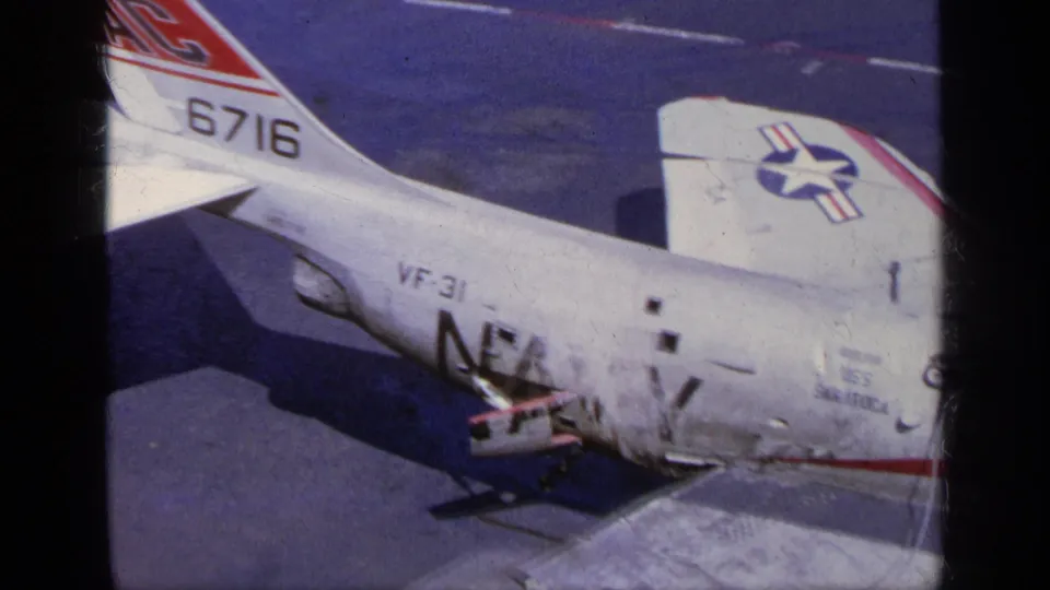 1963 Greece 8mm frame showing the F-104 fuselage, tail number 6716, aircraft insignia, and an open maintenance area.