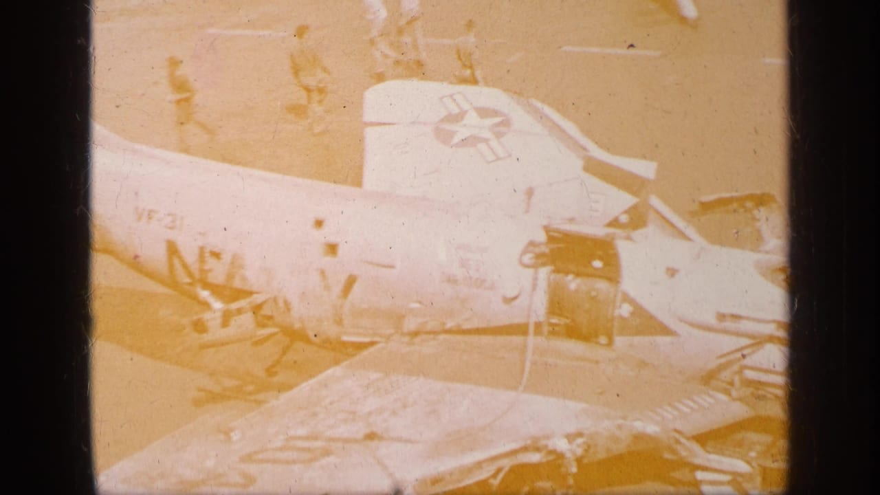 1963 Greece reel frame showing a U.S. military aircraft on a deck or airfield, partly overexposed with insignia and scattered parts visible.
