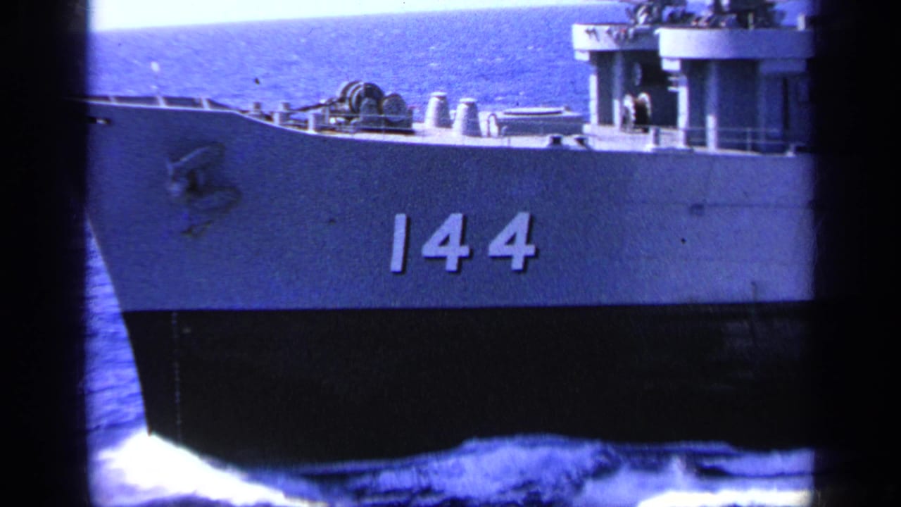 1963 Greece 8mm frame showing a gray naval ship at sea, its hull marked 144, with bow wake and deck structures visible.