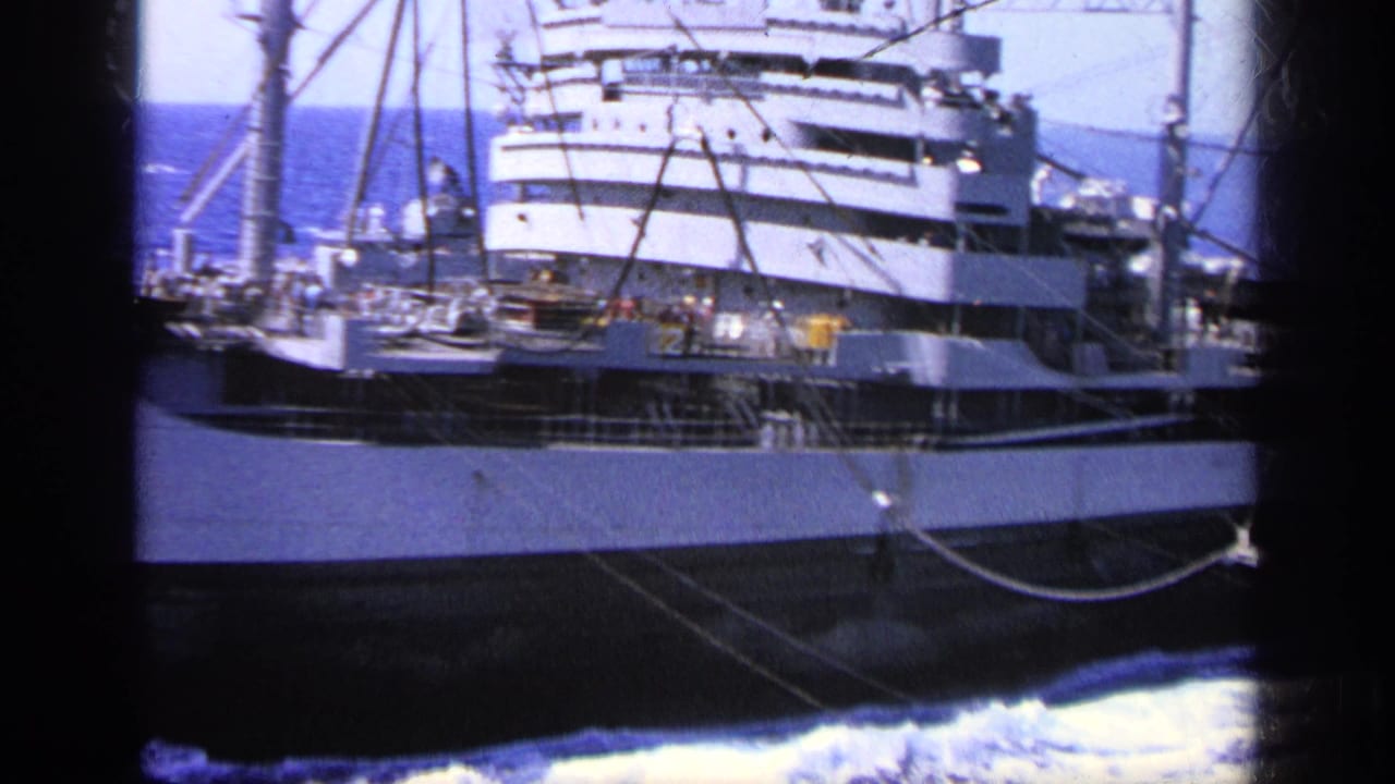 1963 Greece 8mm view of a large cargo ship passing in choppy blue water, with crew visible on deck near the superstructure.