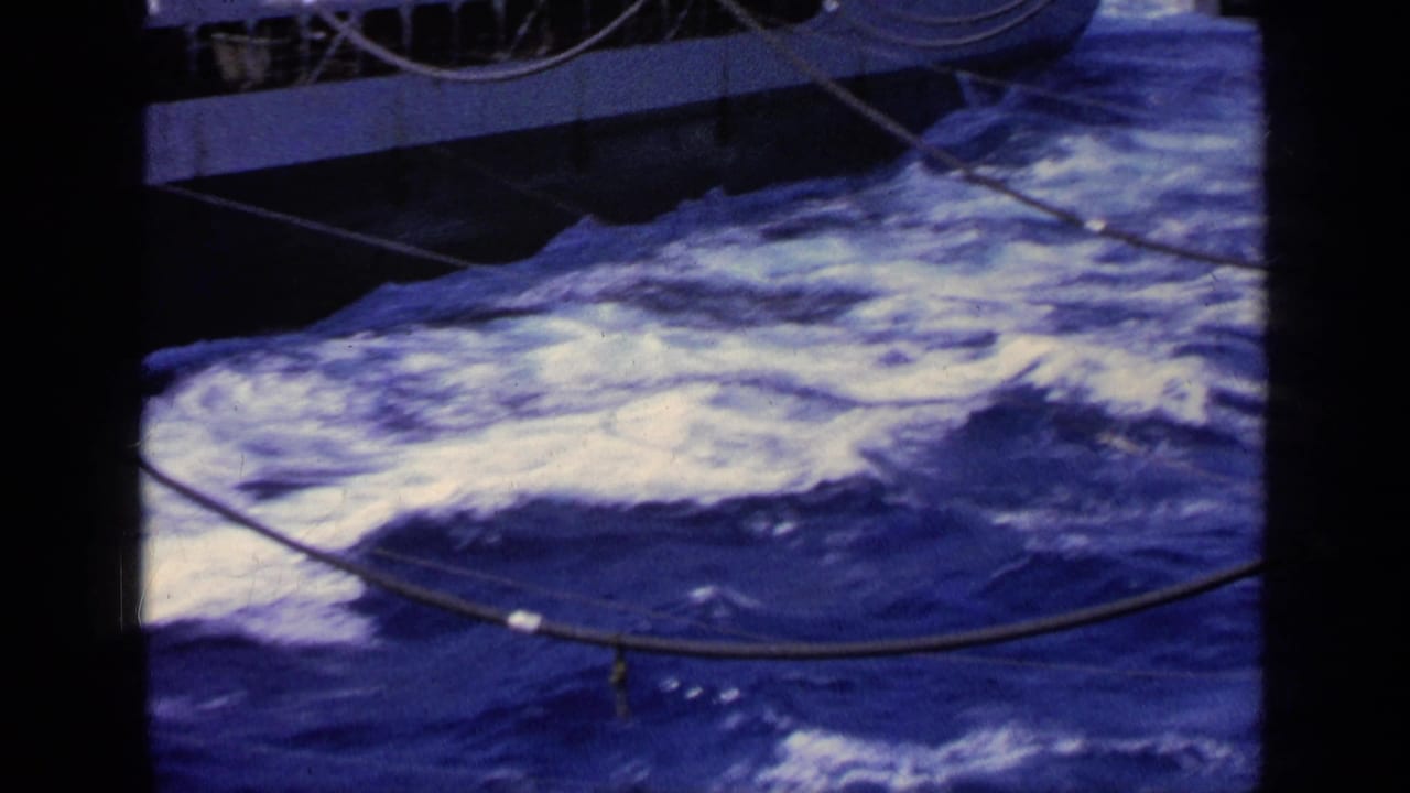 1963 Greece 8mm frame showing churning blue seawater and foam alongside a boat, with rigging cables crossing the deck-side view.
