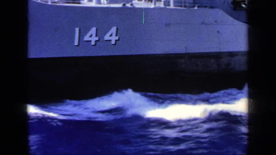 1963 Greece 8mm frame with naval vessel hull number 144 visible over blue sea and white spray.