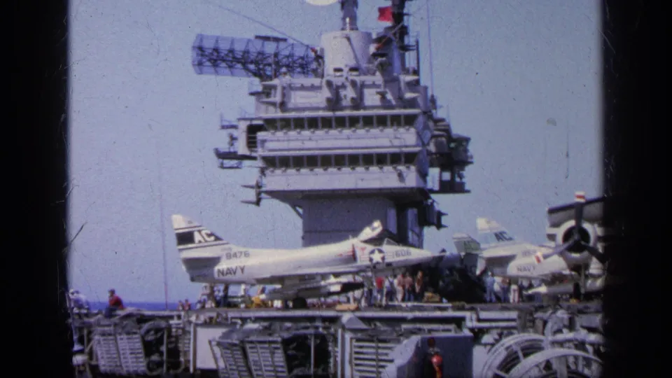 1963 Greece carrier view with Navy jets parked on the flight deck, crew nearby, and radar arrays on the island structure.