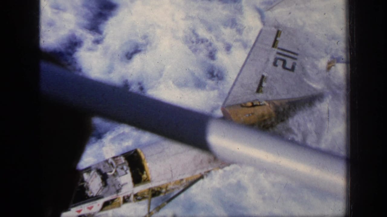 Military jet fragment or aircraft body partly obscured above clouds.