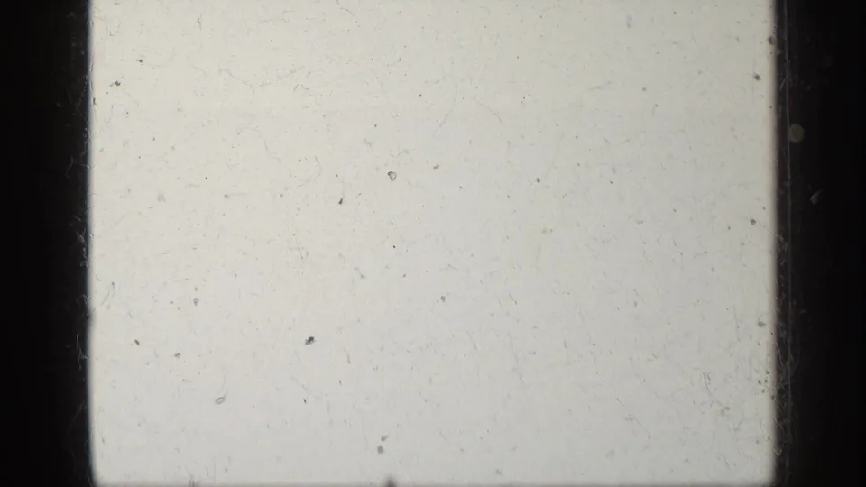 Pale 8mm film leader from the Greece 1963 clip, showing dust, scratches, and dark frame borders.