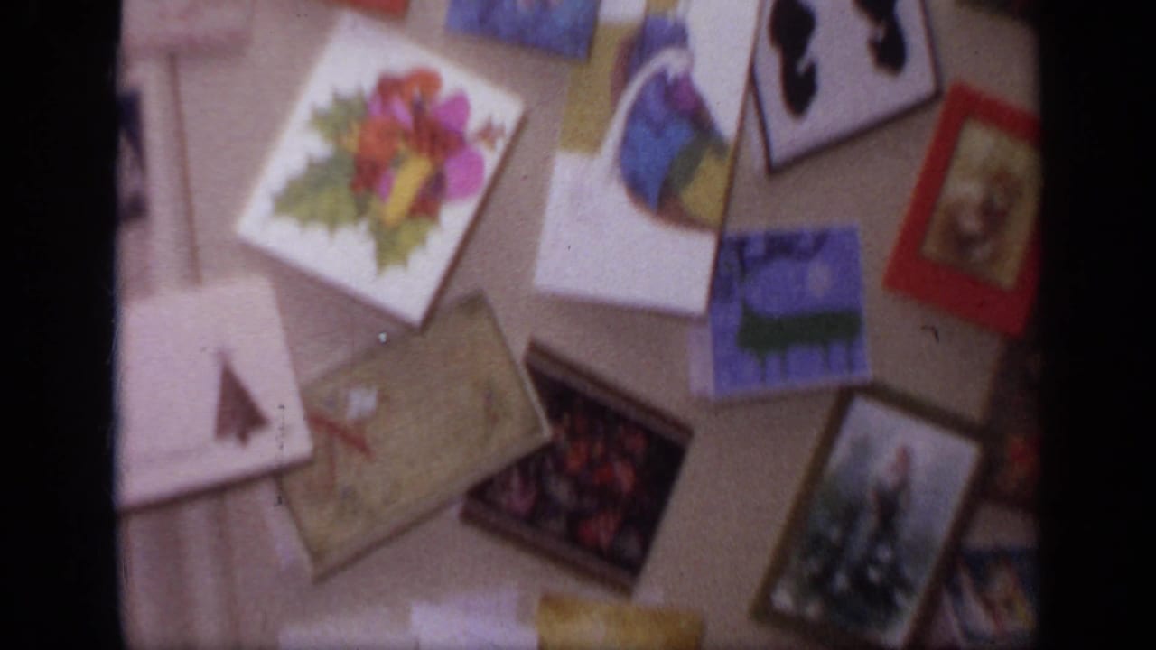 Christmas cards and postcards spread across a household surface.