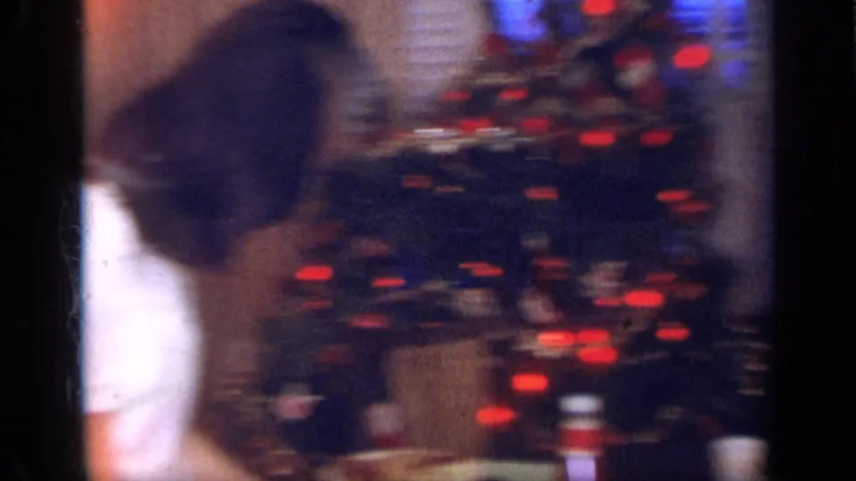 Soft, handheld view of a Christmas tree with red ornaments inside a 1968 California home-movie setting.