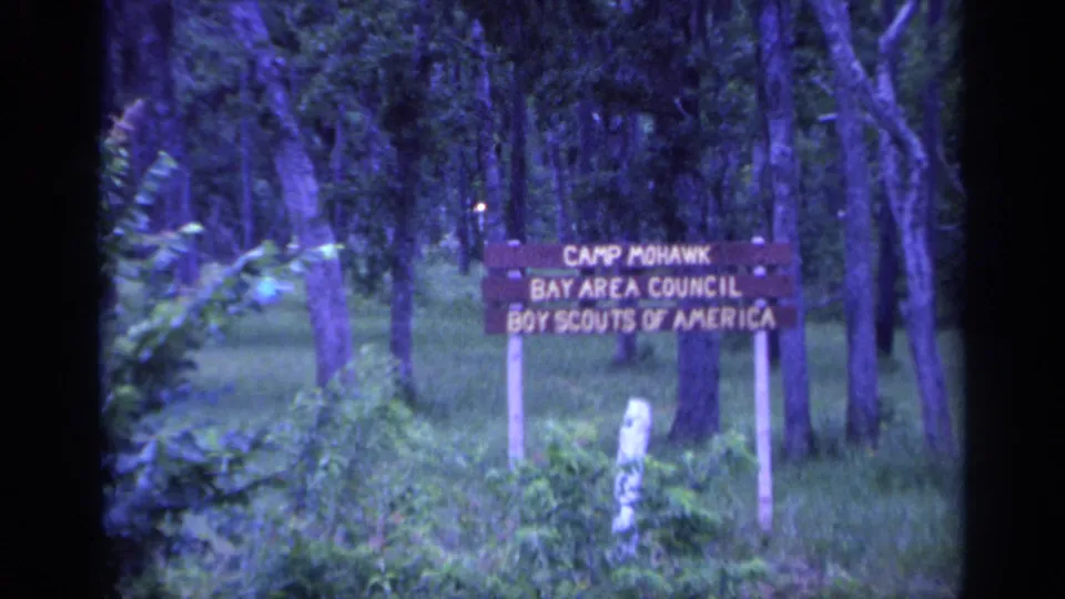 The Camp Mohawk Bay Area Council Boy Scouts of America sign appears in a wooded Florida camp setting.