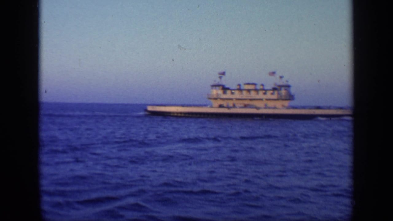 Large multi-deck vessel centered on open water beneath a pale sky.