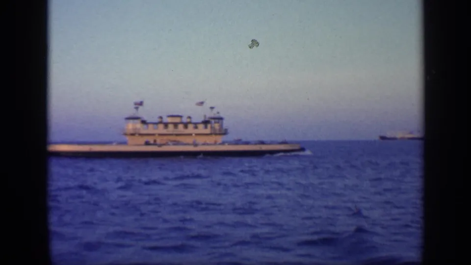 1968 Florida frame showing the large vessel farther across the water, with a small distant ship on the right horizon.