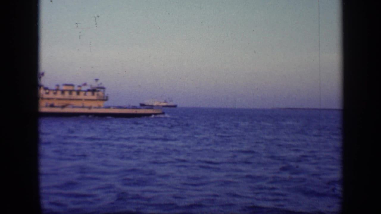 Large vessel near the left side of the frame with open water and a distant ship.